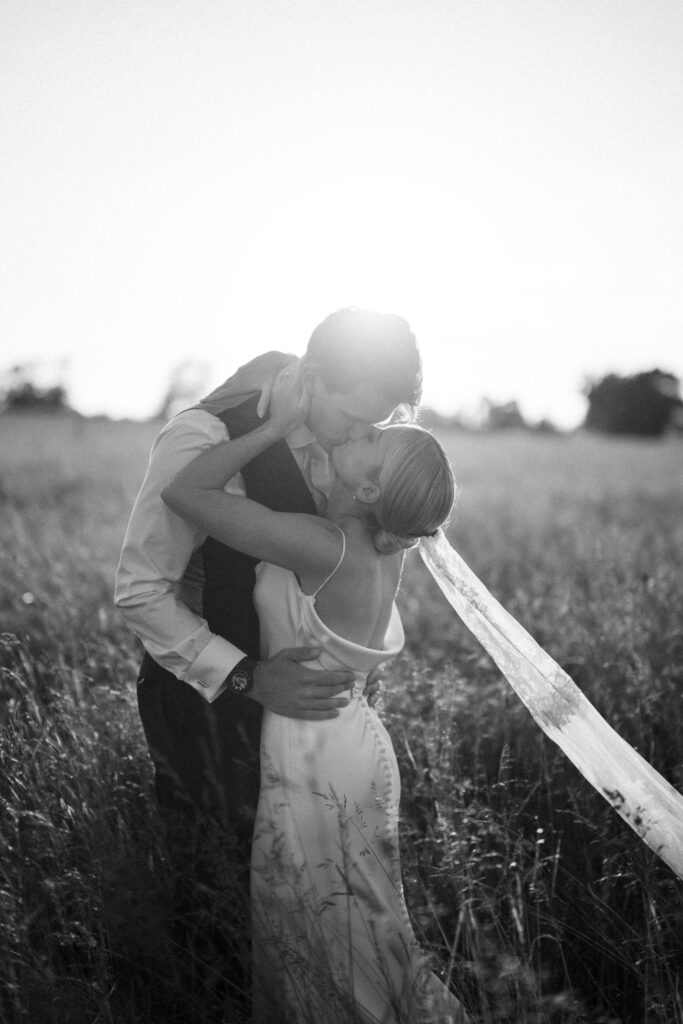 Bride and groom embracing during golden hour in a Suffolk field
