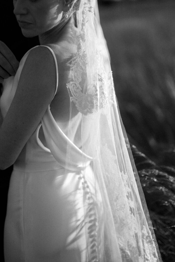 Close up of bride’s lace veil and dress during golden hour