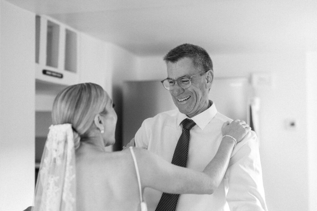 father of bride seeing bride for first time on wedding morning and smiling