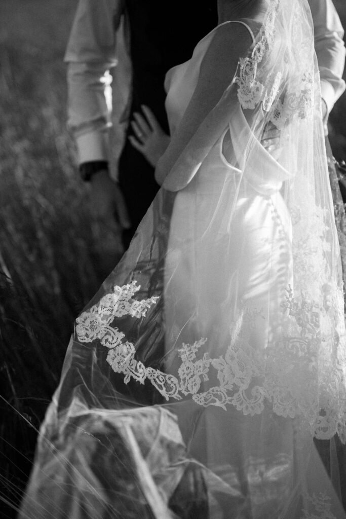 Close up of bride’s lace veil and dress during golden hour