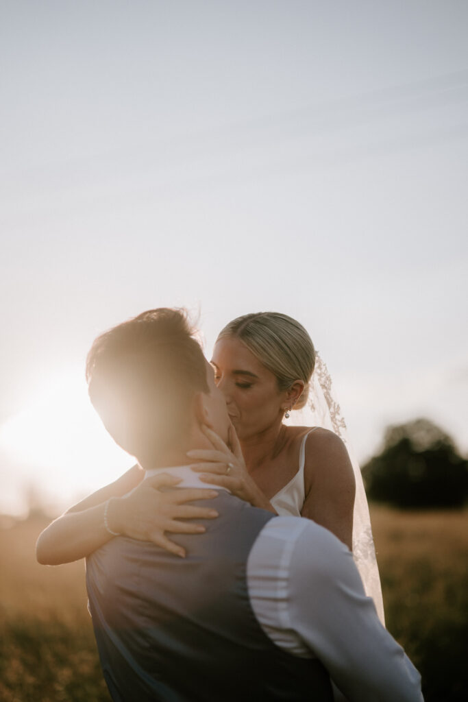 bride and groom sharing a kiss at suffolk wedding venue at golden hour
