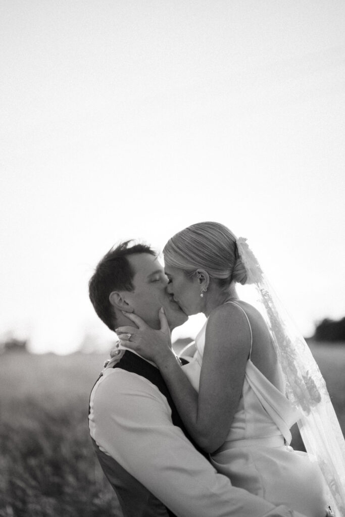 bride and groom sharing a kiss at suffolk wedding venue at golden hour