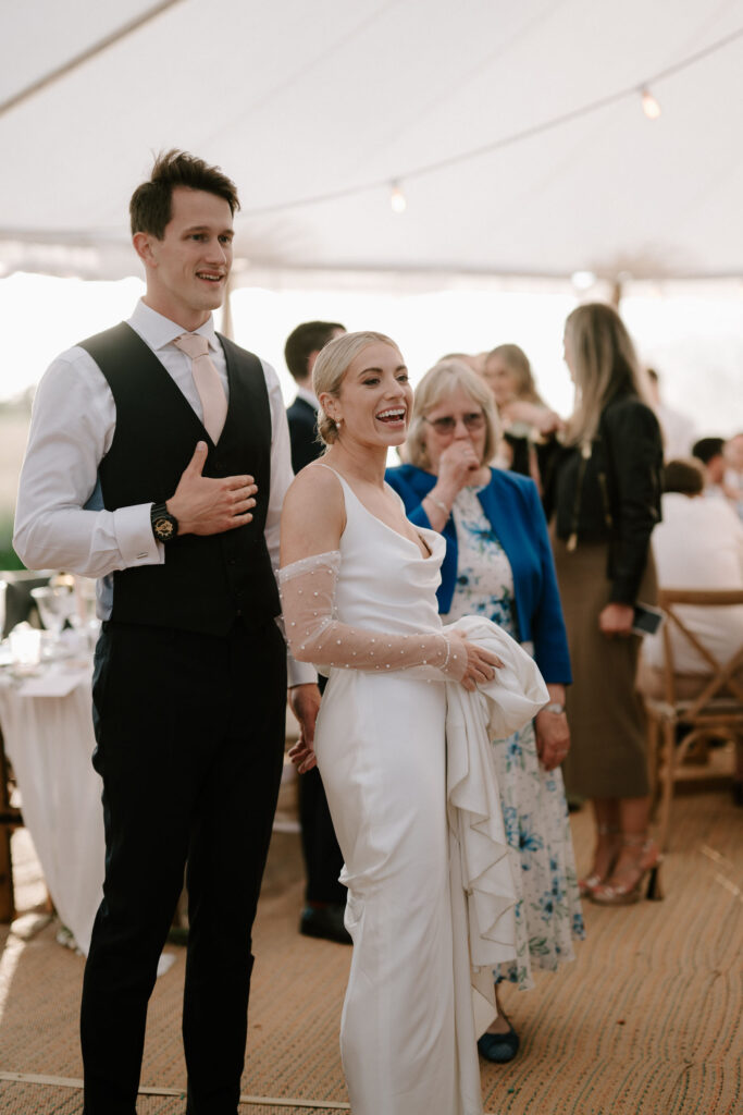 candid moment between bride and groom during reception at marquee wedding in suffolk