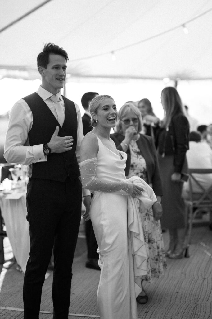 candid moment between bride and groom during reception at marquee wedding in suffolk