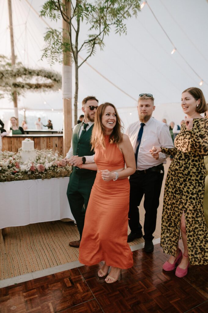 Wedding guests dancing near the bar during marquee reception in Suffolk