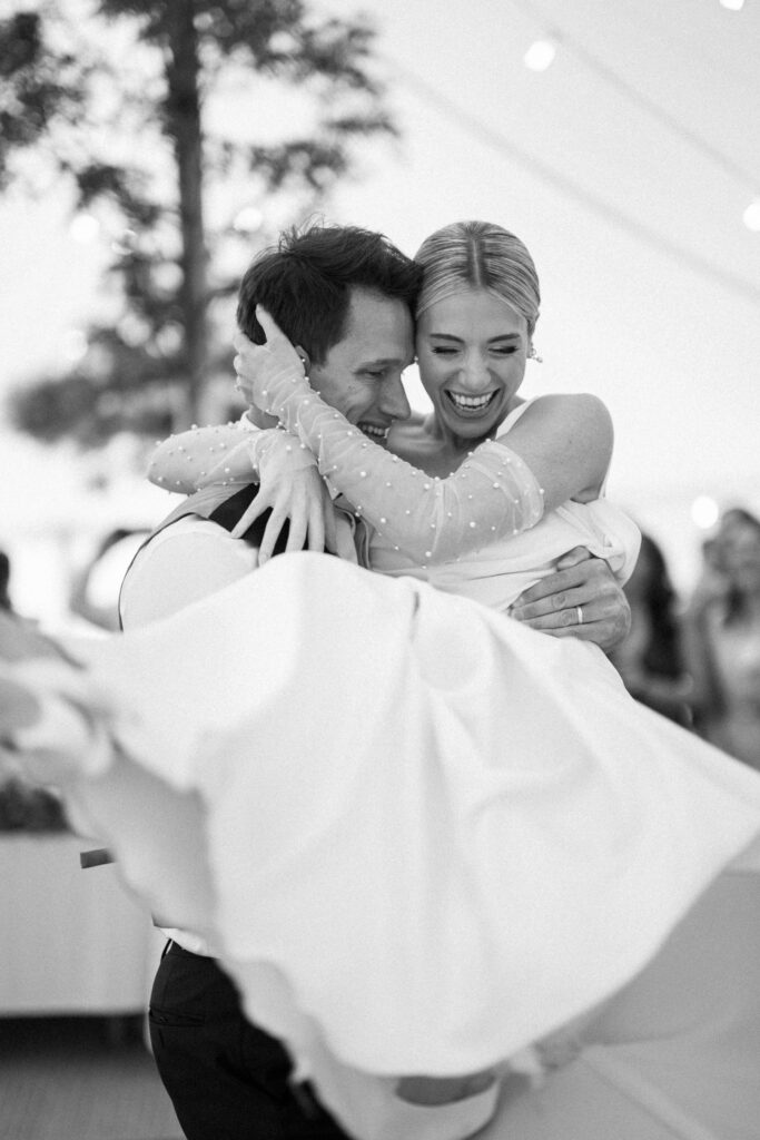 Bride and groom lifted in the air during first dance at marquee wedding reception