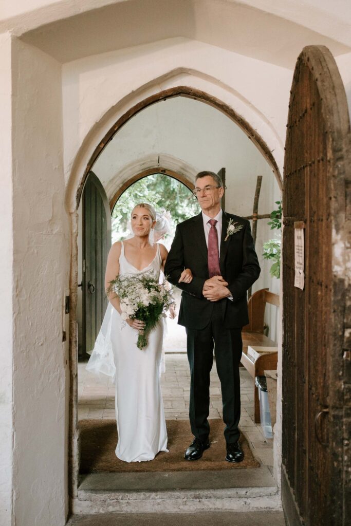 Bride walking down the aisle with her father at the church ceremony