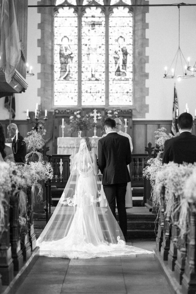 Bride laughing while holding the groom’s hands during the ceremony