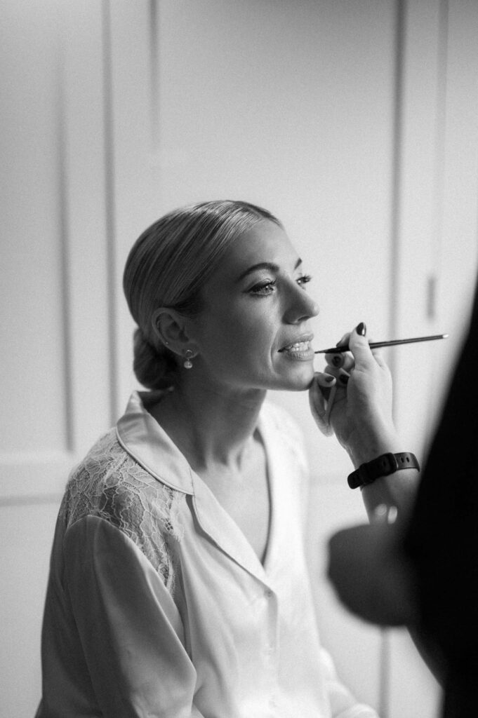 bride having making up done on wedding morning