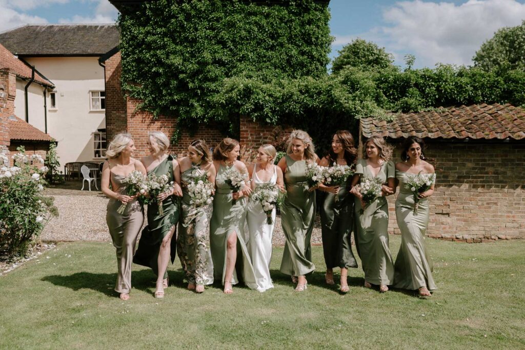 Bridesmaids walking together in a group wearing green dresses