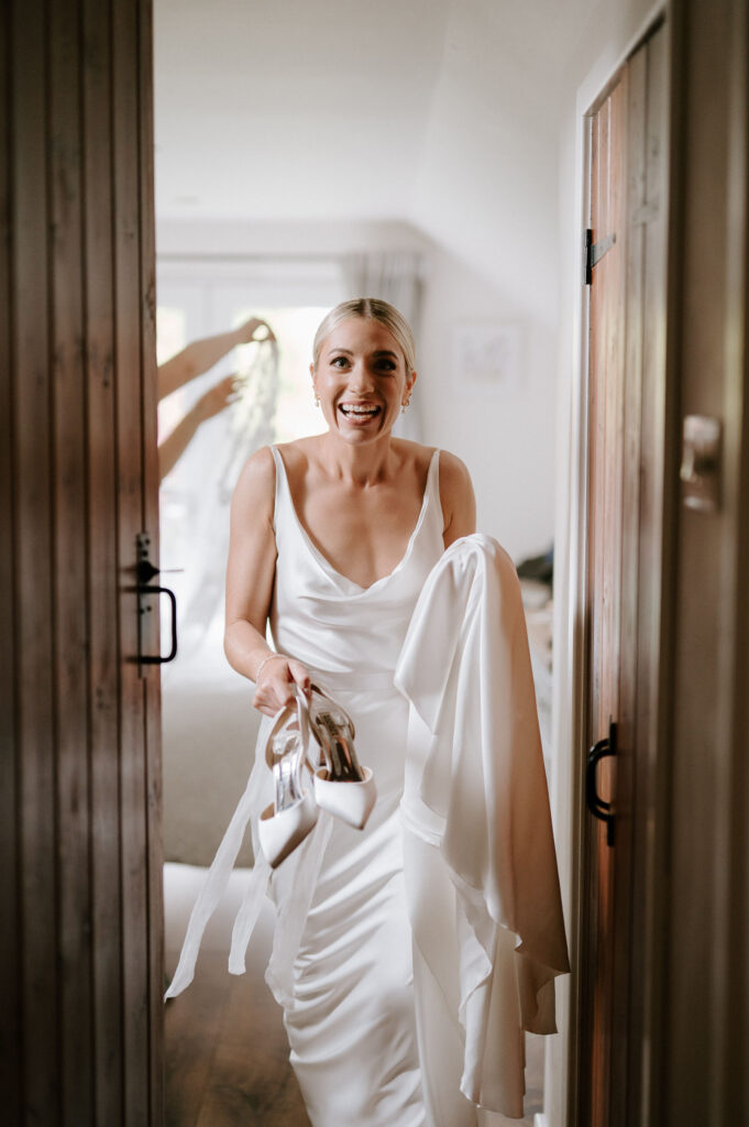 Bride getting ready for her wedding walking holding shoes