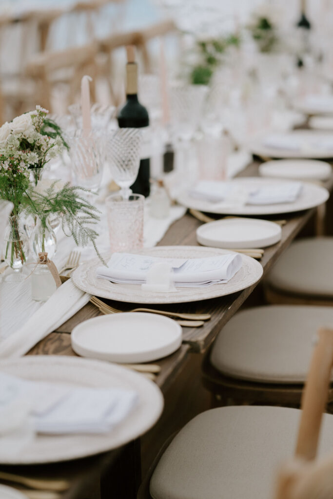 Marquee wedding reception set up with long tables and greenery