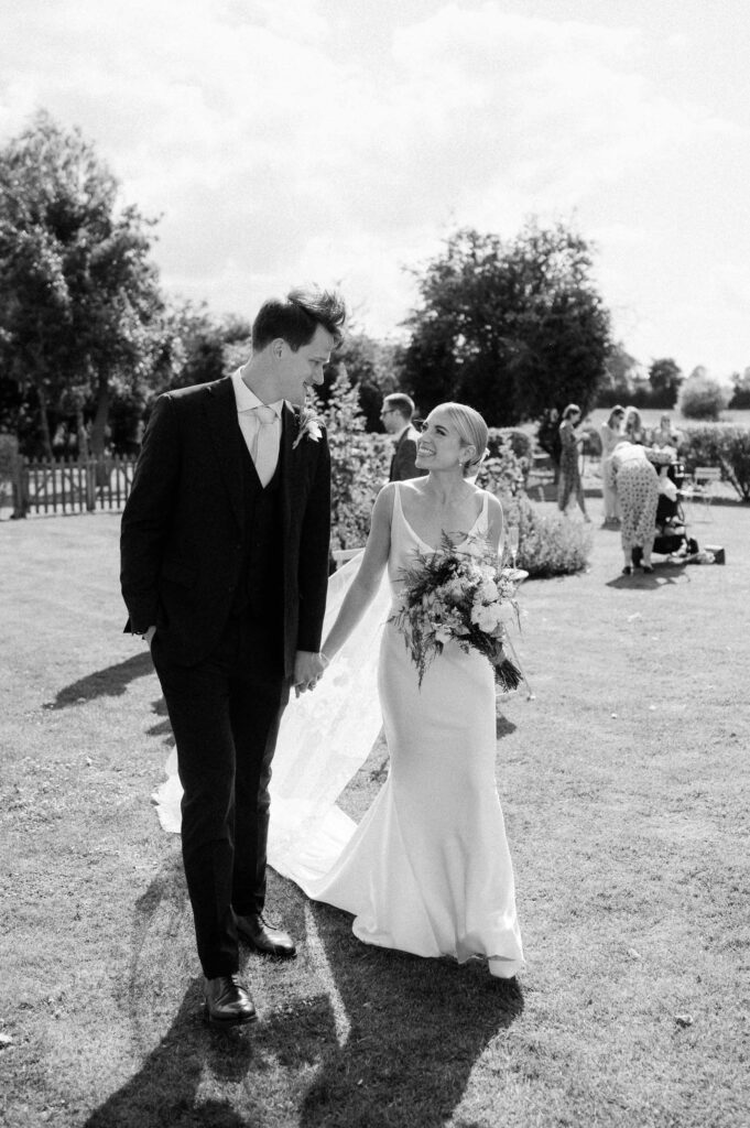 bride and groom walking away from guests during reception at suffolk wedding venue