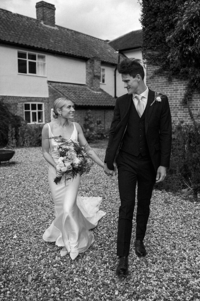 bride and groom walking at suffolk wedding venue