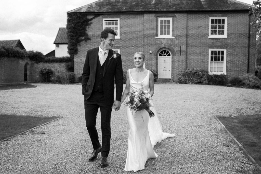 Bride and groom walking side by side across the courtyard after the ceremony