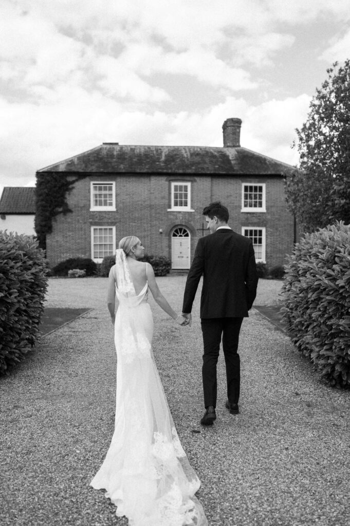 Bride and groom walking together towards the house after their church ceremony