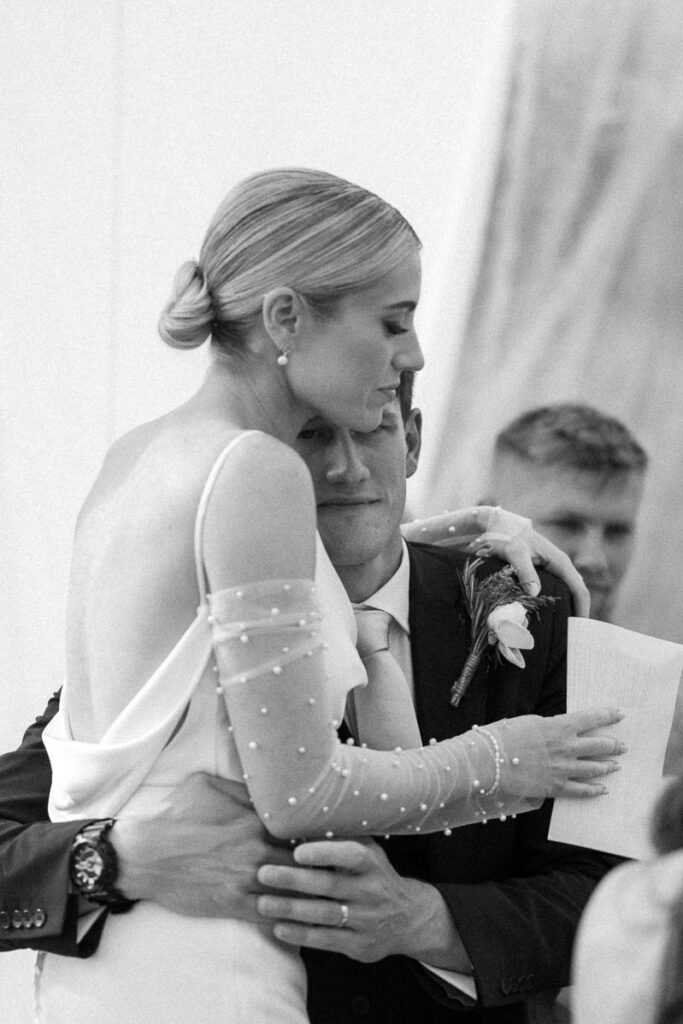 groom hugging bride during wedding speech