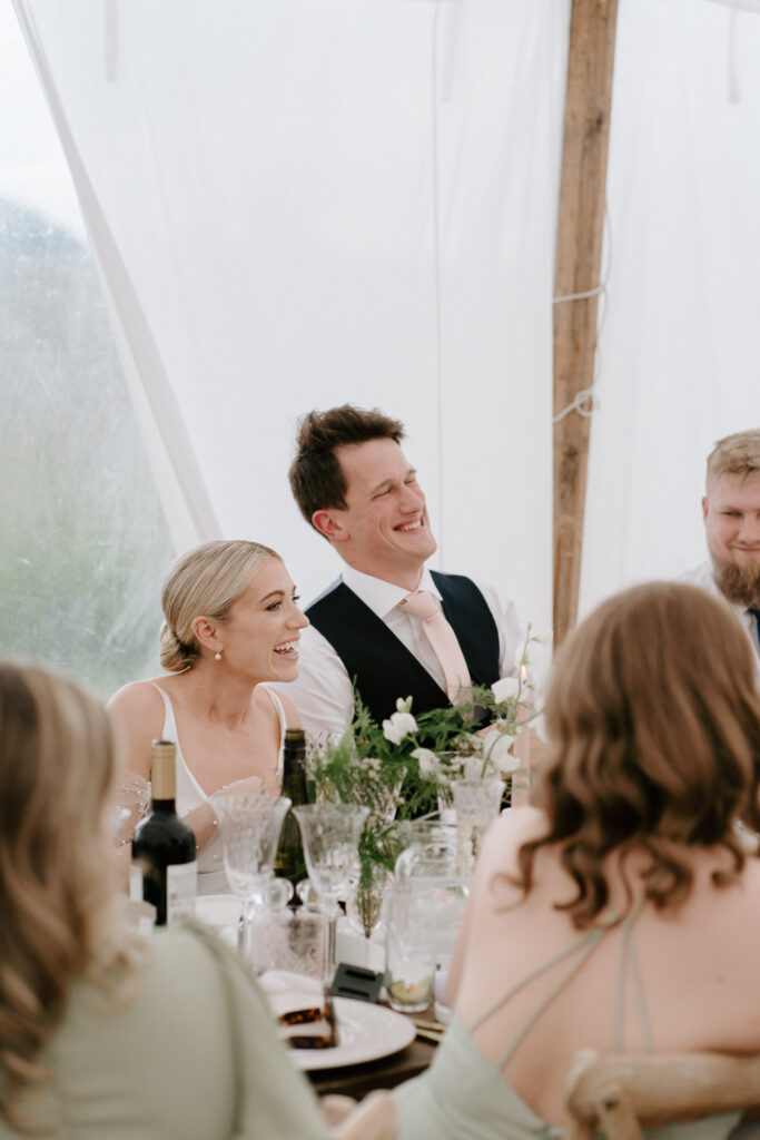 bride and groom laughing at speeches