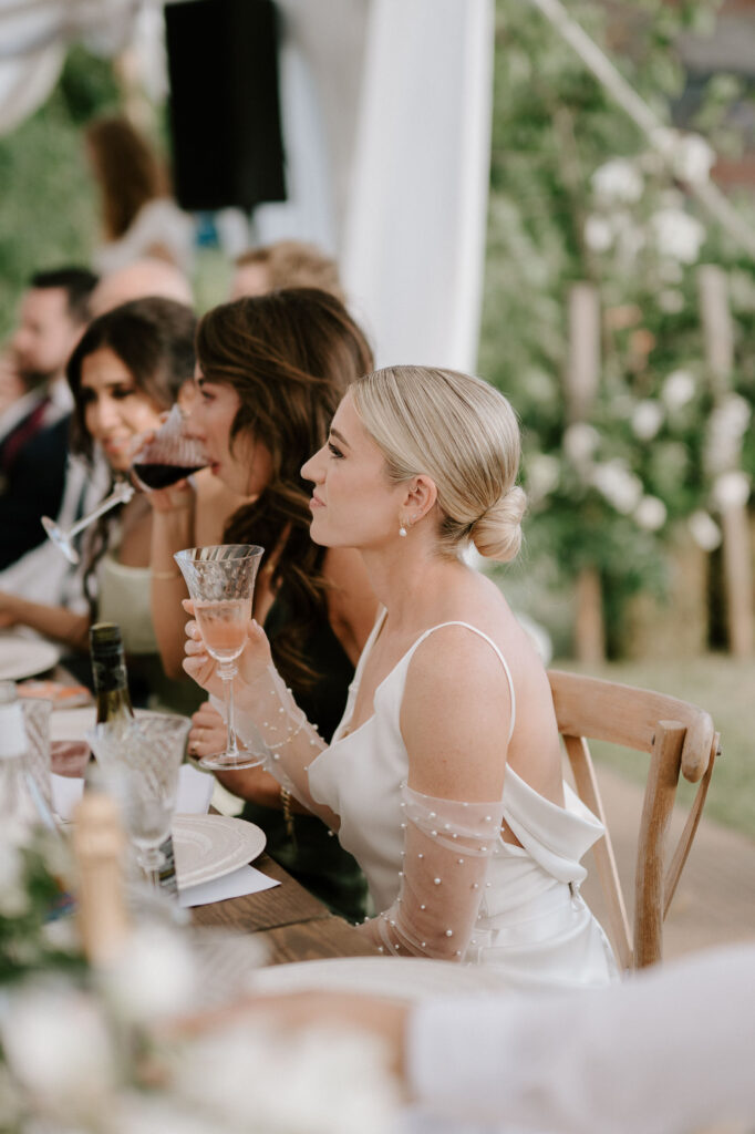 Bride listening to speeches during the marquee wedding reception
