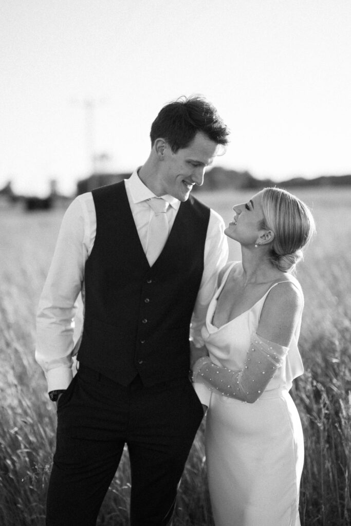 bride and groom looking at each other with pearl sleeves